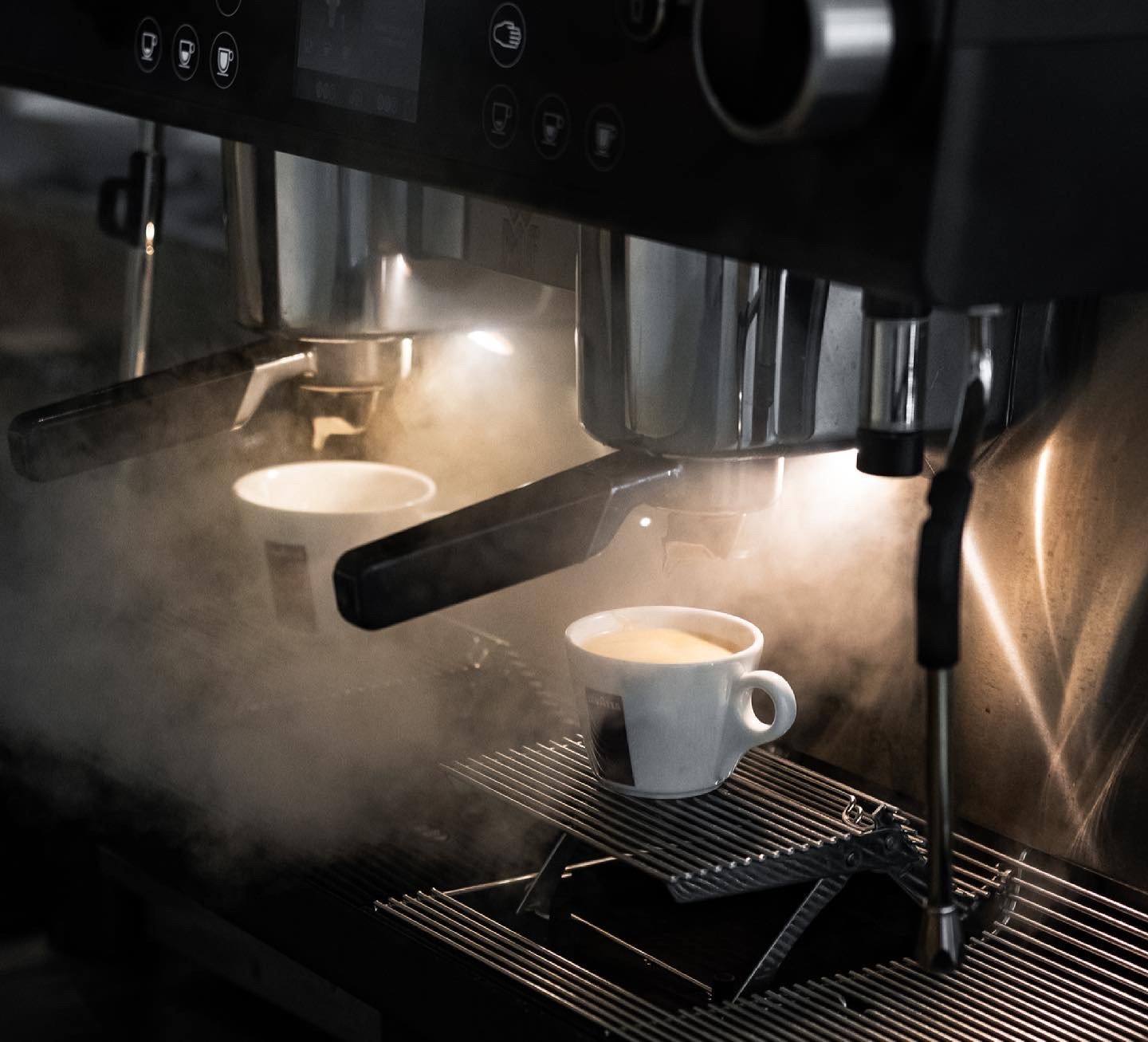 Espresso läuft aus der Siebträgermaschine in eine weiße Tasse